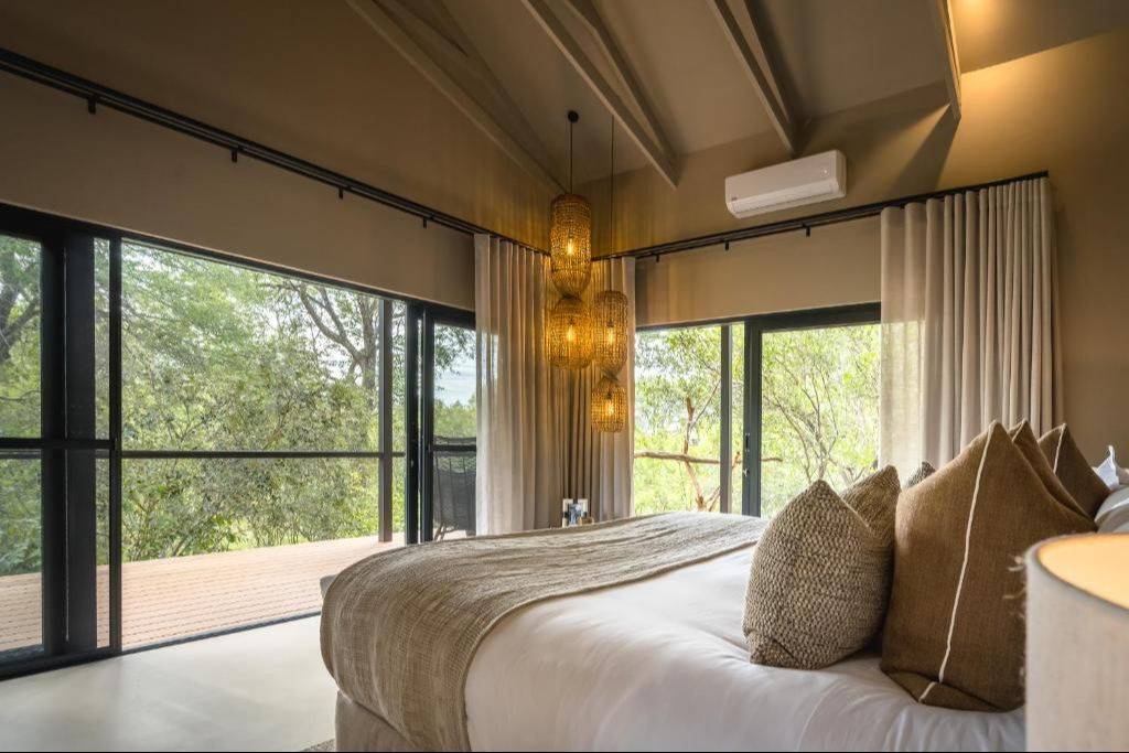 A guest room with floor-to-ceiling bush views